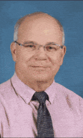 a man wearing glasses and a pink shirt with a black tie