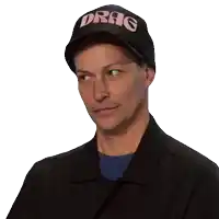 a man wearing a black hat with drag on it
