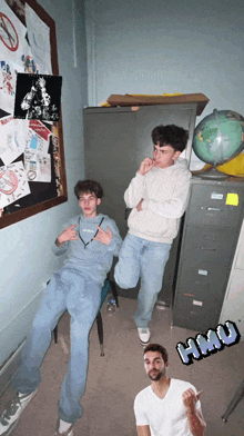 a group of young men are posing for a picture in a room with a globe and a sign that says " hai "