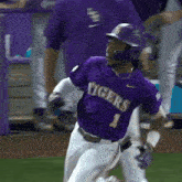 a baseball player in a purple tigers jersey