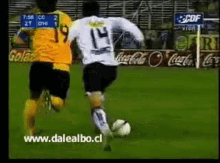 a soccer player wearing the number 14 kicks the ball