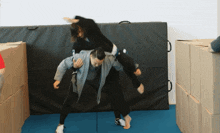 a man is carrying another man on his back and the man is wearing a grey jacket