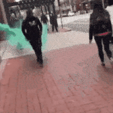 a man and a woman are walking down a sidewalk with a green light coming out of their hands .