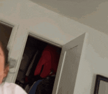 a person in a white shirt is standing in a room with a door open