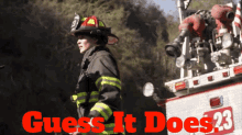 a firefighter stands in front of a fire truck with the words " guess it does 23 " written in red