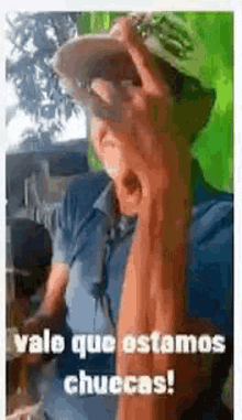 a man wearing a hat and sunglasses is drinking from a glass while making a funny face .