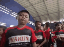 a group of young boys wearing red and black shirts with the word warum on them