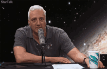 a man sitting in front of a microphone with the word startalk on the bottom right