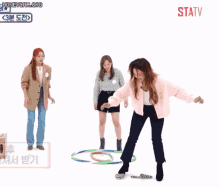 a group of women dancing in front of a sign that says statv