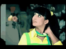 a woman in a yellow shirt and green apron is looking up