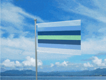 a flag with blue and green stripes is flying in front of a blue sky