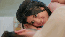 a little girl is smiling while laying on a man 's lap .