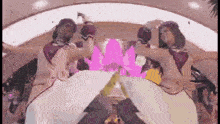 a couple of women are dancing in a room with a pink background .