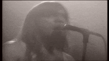 a woman is singing into a microphone on a stage .