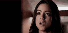 a close up of a woman 's face with a surprised expression on her face .