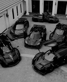 a black and white photo of a row of sports cars with their doors open
