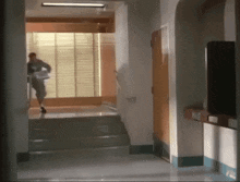a woman is walking down a hallway holding a newspaper