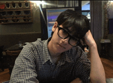 a man wearing glasses is sitting at a table