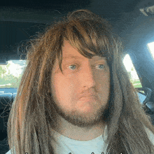 a man with long hair and a beard is wearing a wig and a white shirt