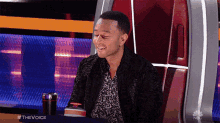a man is sitting in a chair with his eyes closed and the word the voice is on the screen
