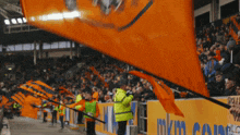 a large orange flag is flying in front of a sign that says mkins