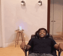 a man wearing headphones sits in a chair in a living room