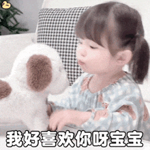 a little girl playing with a stuffed dog with chinese writing on the bottom