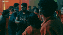a man wearing sunglasses is pointing at another man in an xtoms / 2005 advertisement