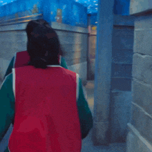 a man in a green and red jacket is carrying a woman