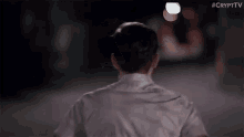 the back of a man walking down a street at night .