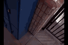 a blue locker is next to a brick wall and a black railing