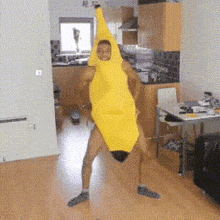 a man in a banana costume is dancing in a kitchen .