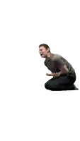 a man in a grey shirt is kneeling down and laughing