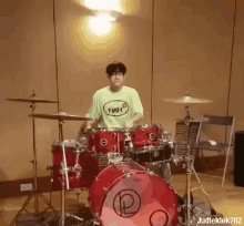 a young man wearing a 1991 shirt is playing drums