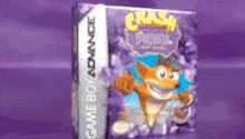 a game boy advance crash bandicoot video game is sitting on a purple table .