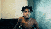 a shirtless man with a tattoo on his arm that says ' i 'm a bitch '