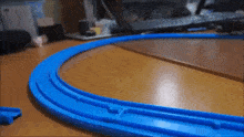 a blue toy train track is on a table