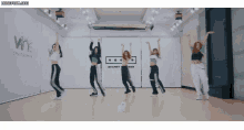 a group of women are dancing in front of a sign that says wne