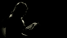 a silhouette of a man in a suit and tie in the dark