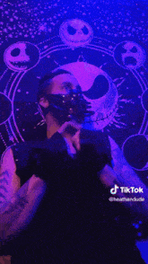 a man wearing a mask is standing in front of a nightmare before christmas wall tapestry