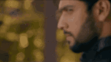 a close up of a man 's face with a beard making a serious face .