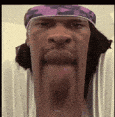 a man wearing a purple headband with his tongue out