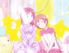 two anime girls are sitting next to each other on a couch