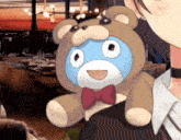 a person holding a teddy bear with a bow tie on it
