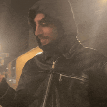 a man wearing a black jacket with a hood on