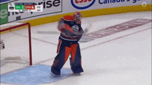 a hockey goalie stands on the ice in front of a scoreboard that says rise on it