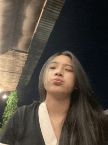 a woman with long hair is making a funny face with her eyes closed