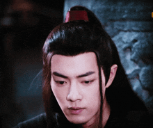 a close up of a man 's face with long black hair