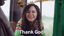 a woman is smiling and saying thank god while sitting in a car .