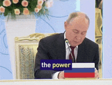 a man sits at a table with a sign that says the power on it